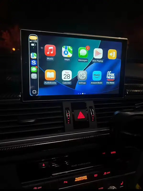 Écran CarPlay affichant la grille d’applications dans une console centrale
